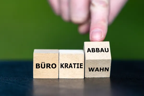 Drei Würfel mit der Aufschrift Bürokratie/Wahn/Abbau